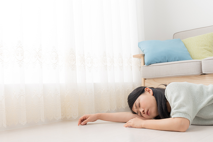 失神しソファーの下に横たわる女性